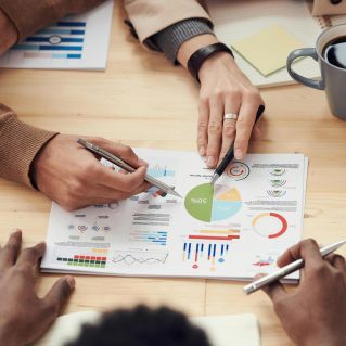 Colleagues discussing data and strategy in an office meeting.